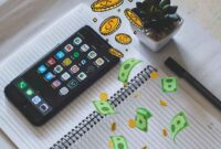 Membuka hp di atas buku (pexels)