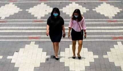Dua orang wanita sedang berjalan saat Hari Tanpa Bayangan
