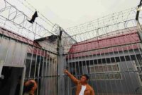 Petugas Lapas Siak menunjuk pagar yang menjadi pelarian napi narkotika kabur dari sel, Minggu (19/10/2025) (Foto: Polres Siak)