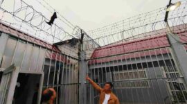 Petugas Lapas Siak menunjuk pagar yang menjadi pelarian napi narkotika kabur dari sel, Minggu (19/10/2025) (Foto: Polres Siak)