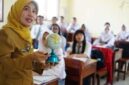Seorang guru sedang memegang bola dunia  sambil mengajar para siswa di ruang kelas (Foto: Dokumentasi indonesia.go.id)