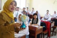 Seorang guru sedang memegang bola dunia  sambil mengajar para siswa di ruang kelas (Foto: Dokumentasi indonesia.go.id)