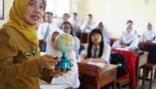 Seorang guru sedang memegang bola dunia  sambil mengajar para siswa di ruang kelas (Foto: Dokumentasi indonesia.go.id)