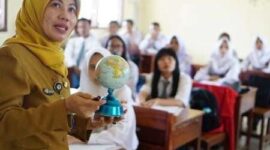 Seorang guru sedang memegang bola dunia  sambil mengajar para siswa di ruang kelas (Foto: Dokumentasi indonesia.go.id)