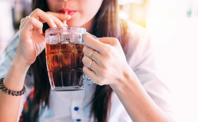 Ilustrasi seorang wanita mengonsumsi minuman bersoda. (Foto: Shutter Stock)
