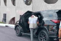 Salah seorang personil KPK melakukan penggeledahan di mobil dinas Plt Gubernur Riau SF Hariyanto (Foto: RRI/Femmy Asti Yofani)