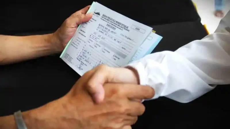 Petugas Unit Pengelola Zakat (UPZ) melayani pembayaran zakat, fidyah, kafarat, infaq, dan shadaqah di teras Masjid Istiqlal, Jakarta, Minggu 15 Maret 2026. (Kapanlagi.com)