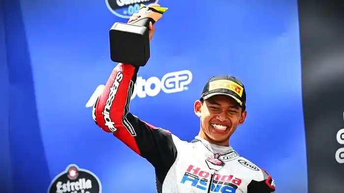 Pembalap Indonesia, Veda Ega Pratama, mengangkat trofi pertamanya di podium setelah finis ketiga dalan balapan Moto3 Brasil 2026 di Sirkuit Ayrton Senna, Brasil, Minggu (22/3/2026). ist
