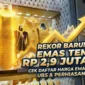Ilustrasi - Tumpukan emas batangan Antam dan grafik harga emas naik.