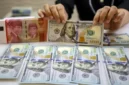 Karyawan memperlihatkan uang Rupiah dan Dolar AS di salah satu tempat penukaran uang asing di Jakarta, Senin (20/10/2025). (Bisnis)