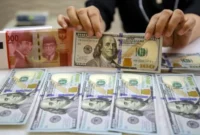 Karyawan memperlihatkan uang Rupiah dan Dolar AS di salah satu tempat penukaran uang asing di Jakarta, Senin (20/10/2025). (Bisnis)