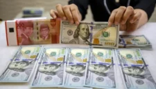 Karyawan memperlihatkan uang Rupiah dan Dolar AS di salah satu tempat penukaran uang asing di Jakarta, Senin (20/10/2025). (Bisnis)