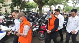 Varial Adhi Putra (belakang berjaket oranye) saat digiring petugas bersama satu tersangka lainnya.