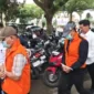 Varial Adhi Putra (belakang berjaket oranye) saat digiring petugas bersama satu tersangka lainnya.