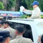 Presiden Prabowo Subianto melemparkan kaos dari atas mobilnya di Gorontalo, Sabtu (9/5/2026). (KOMPAS.com)