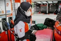 Petugas SPBU sedang Melakukan Pengisian BBM ke Kendaraan.
