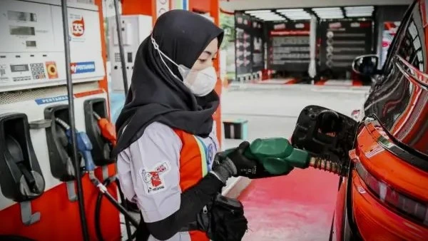 Petugas SPBU sedang Melakukan Pengisian BBM ke Kendaraan.