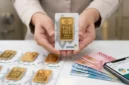 Pedagang Memperlihatkan Emas Batangan Produksi PT Aneka Tambang (Antam).