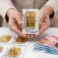 Pedagang Memperlihatkan Emas Batangan Produksi PT Aneka Tambang (Antam).