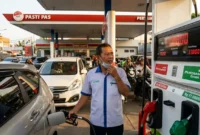 Petugas SPBU Sedang Melayani Konsumen.