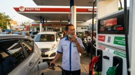 Petugas SPBU Sedang Melayani Konsumen.