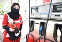 Petugas SPBU sedang melakukan pengisian BBM ke kendaraan.