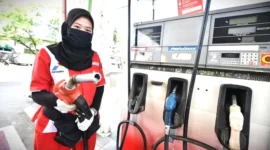 Petugas SPBu sedang melakukan pengisian BBM ke kendaraan.
