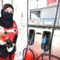 Petugas SPBu sedang melakukan pengisian BBM ke kendaraan.