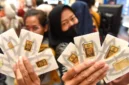 Ilustrasi - Pengunjung menunjukkan logam mulia Antam yang dibeli di Jakarta. ANTARA Foto