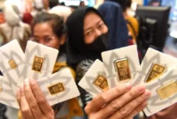Ilustrasi - Pengunjung menunjukkan logam mulia Antam yang dibeli di Jakarta. ANTARA Foto