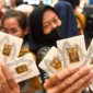 Ilustrasi - Pengunjung menunjukkan logam mulia Antam yang dibeli di Jakarta. ANTARA Foto