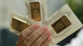 Foto: Karyawati menunjukkan emas PT Aneka Tambang Tbk. (Antam) di salah satu gallery penjualan emas di Jakarta, Selasa (16/7/2024). (CNBC Indonesia)