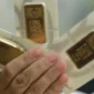 Foto: Karyawati menunjukkan emas PT Aneka Tambang Tbk. (Antam) di salah satu gallery penjualan emas di Jakarta, Selasa (16/7/2024). (CNBC Indonesia)