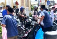 Aksi pembagian nasi kotak di depan masjid al akbar desa gedang.